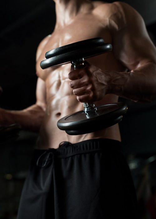 close-up-of-man-with-dumbbells-exercising-in-gym-PNGBLV9-min.jpg